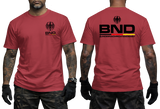 red tactical t-shirt featuring the BND eagle emblem and logo on the chest. The back shows a large BND print with the full Bundesnachrichtendienst name and German flag colors.