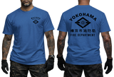 A man modeling a royal blue short-sleeve t-shirt, showing both the front and back views. The front features a small black Yokohama Fire Department emblem on the left chest, and the back features a large black Yokohama Fire Department graphic with the text 'YOKOHAMA FIRE DEPARTMENT'.