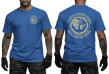 Two-view composite image of a blue t-shirt featuring Polish Navy Special Forces JW Formoza graphics. The left side shows the front of the shirt with a small circular chest emblem. The right side shows the back of the shirt with a large circular crest featuring the unit's emblem and motto text. The shirt is displayed on a male model with tattooed arms and tactical gloves.