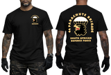 Front and back views of a man wearing a black SADF 44 Parachute Brigade T-Shirt. Features a parachute and eagle head emblem on the left chest and a large back graphic displaying "44 Parachute Brigade South African Defence Force" with the airborne crest.