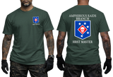 Front and back view of a dark green t-shirt featuring the US Marine Corps Amphibious Raids Branch HRST Master logo. The front features a small unit shield insignia with a skull and stars on the left chest. The back displays a large version of the same insignia with 'AMPHIBIOUS RAIDS BRANCH' above it and 'HRST MASTER' below.