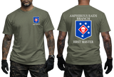 Front and back view of a military green t-shirt featuring the US Marine Corps Amphibious Raids Branch HRST Master logo. The front features a small unit shield insignia with a skull and stars on the left chest. The back displays a large version of the same insignia with 'AMPHIBIOUS RAIDS BRANCH' above it and 'HRST MASTER' below.