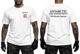 Two-panel photo showing the front and back of a white short-sleeve t-shirt. The front features a small circular "Antarctic Fire Department McMurdo Station" logo on the left chest. The back displays large white text: "ANTARCTIC FIRE DEPARTMENT McMurdo Station