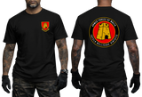A black short-sleeve t-shirt shown on a model from both the front and back. The front features a small red and yellow military-style crest on the left chest.