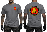 A man modeling a gray short-sleeve t-shirt, showing both the front and back views. The front features a small red and yellow military crest on the left chest.