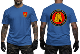 A man modeling a royal blue t-shirt, showing both the front and back views. The front features a small red and gold military crest on the left chest.