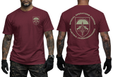 A man modeling a maroon short-sleeve t-shirt, showing both the front and back views. The front features a small shield crest on the left chest, while the back displays a large matching crest with the text 'SPECIAL OPERATIONS FORCES AUSTRIA JAGGKOMMANDO'.