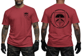 A man modeling a red short-sleeve t-shirt, showing both the front and back views. The front features a small black shield logo on the left chest, and the back features a large black shield graphic with the text 'SPECIAL OPERATIONS FORCES' and 'AUSTRIA JAGOKOMMANDO'.