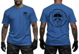 A man modeling a blue short-sleeve T-shirt, shown from the front and back. The front has a small black shield logo on the left chest, and the back has a large black Special Operations Forces Austria Jagdkommando graphic with a parachute emblem and text.
