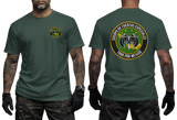 A man modeling a dark green t-shirt, showing both the front and back views. The front features a small circular emblem on the left chest, while the back displays a large circular emblem with the Spanish text 'GUERRA DE FUERZAS ESPECIALES' and '1000 POR MEXICO'.