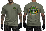 Front and back views of an olive green t-shirt worn by a model. The front features a small circular emblem on the left chest, while the back displays a large circular graphic with the Spanish text 'GUERRA DE FUERZAS ESPECIALES' and '100% POR MEXICO' surrounding a military-style emblem.