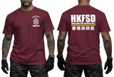 A man modeling a maroon short-sleeve t-shirt, showing both the front and back views. The front features a white HKFSD fire department crest on the left chest, and the back features large white 'HKFSD' text with 'HONG KONG FIRE SERVICES DEPT.