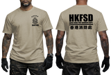 A man modeling a beige short-sleeve t-shirt, showing both the front and back views. The front features a small black HKFSD crest on the left chest, and the back features a large black 'HKFSD HONG KONG FIRE SERVICES DEPT' print with Chinese characters.