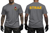 A man modeling a gray short-sleeve t-shirt, showing both front and back views. The front features a small yellow, red, and black firefighter emblem on the left chest.