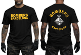 A man modeling a black short-sleeve t-shirt with yellow 'BOMBERS BARCELONA' text on the front and a large yellow-and-white club crest on the back