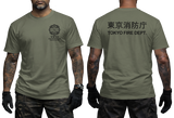 Military green Tokyo Fire Department (TFD) tactical t-shirt. Features the official orange fire rescue emblem on the chest and bold Japanese Kanji 'Tokyo Shofochu' text on the back. A rugged, military-inspired colorway for Japanese first responder enthusiasts. Available in sizes S-5XL.